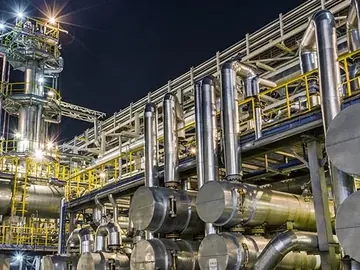 Pipe racks and process piping of an industrial plant lit at night