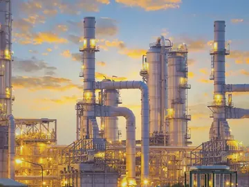 Refinery distillation columns against an evening sky